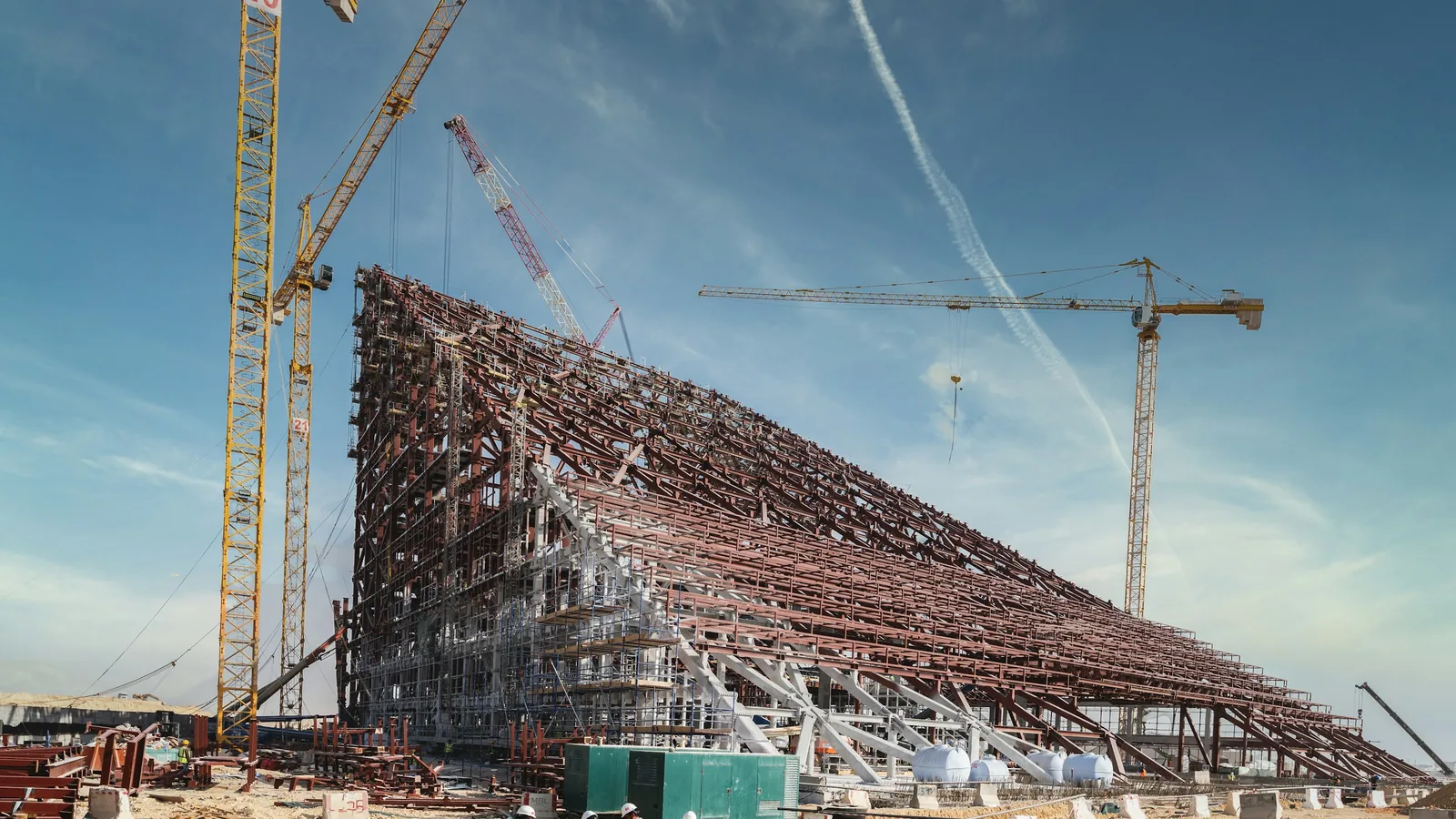Tower cranes over the steel frame of a large building under construction
