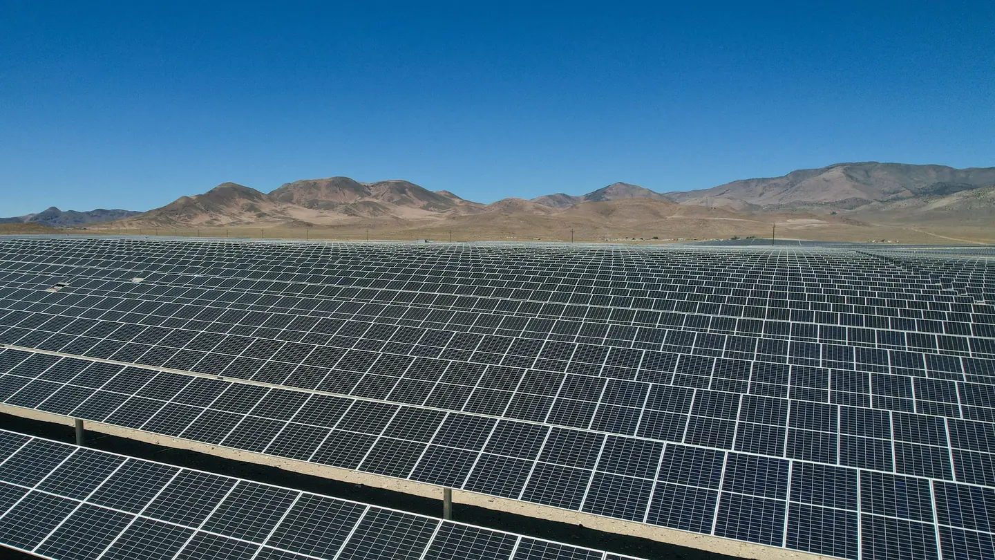 Rows of solar panels stretching across a desert plain
