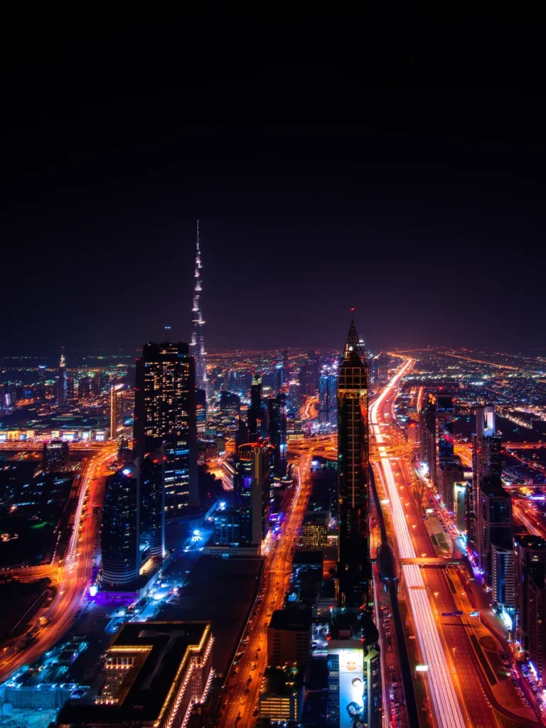 Downtown Dubai at night from above, with light trails along the main road