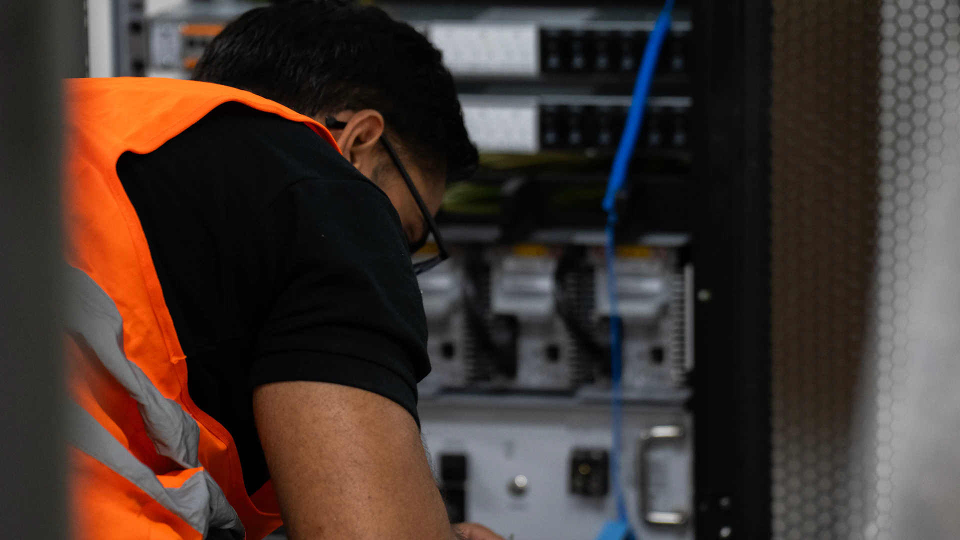 An engineer working on equipment in a server rack