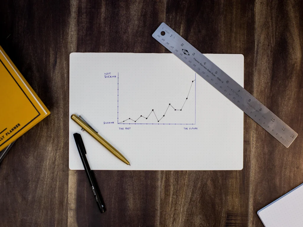 A hand-drawn growth chart on paper with a ruler and pens