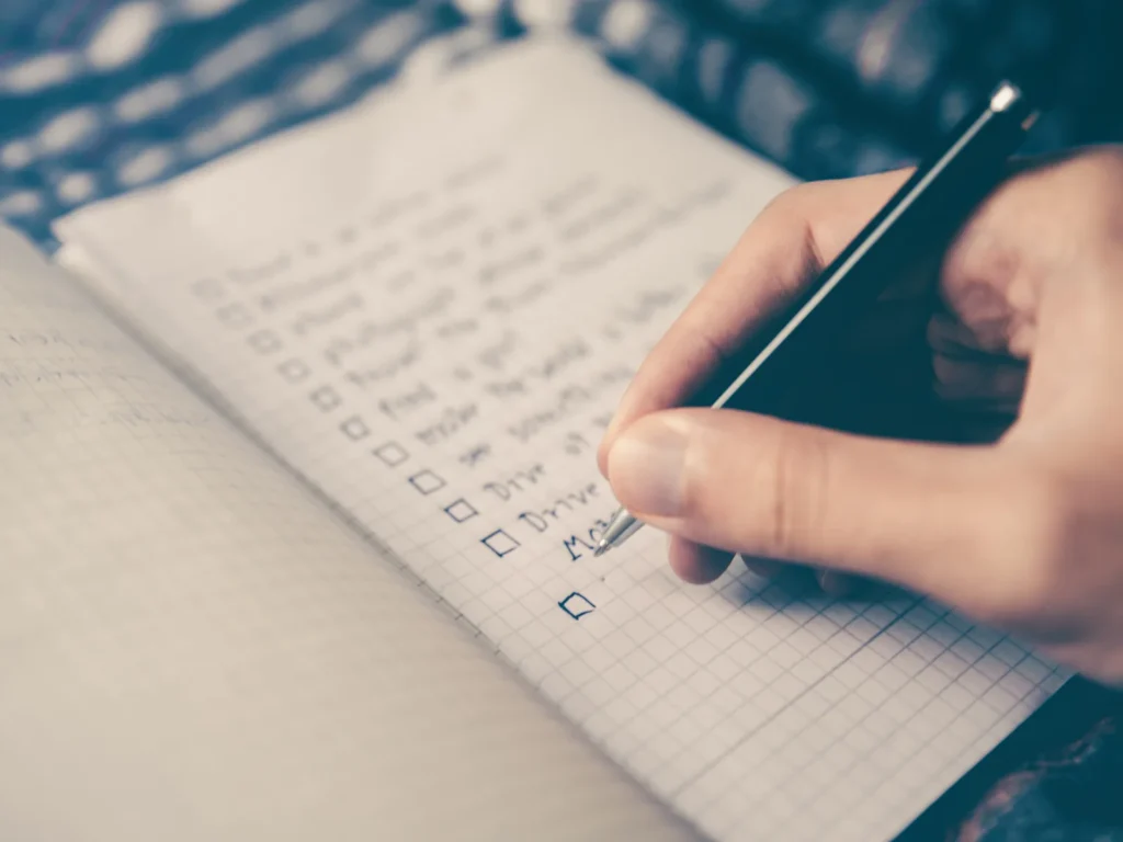 A hand ticking through a handwritten checklist