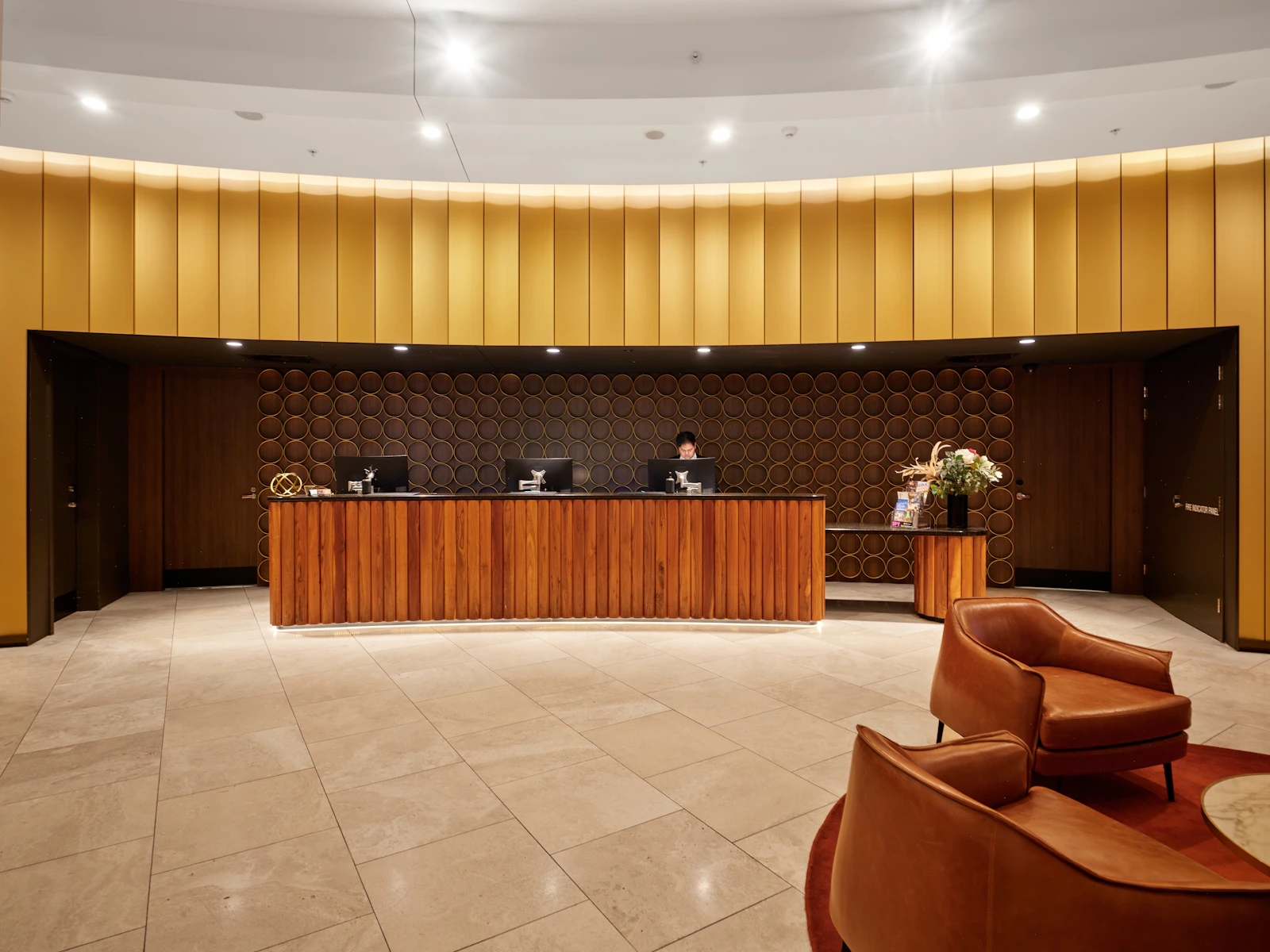 A warm hotel reception with staff at the front desk
