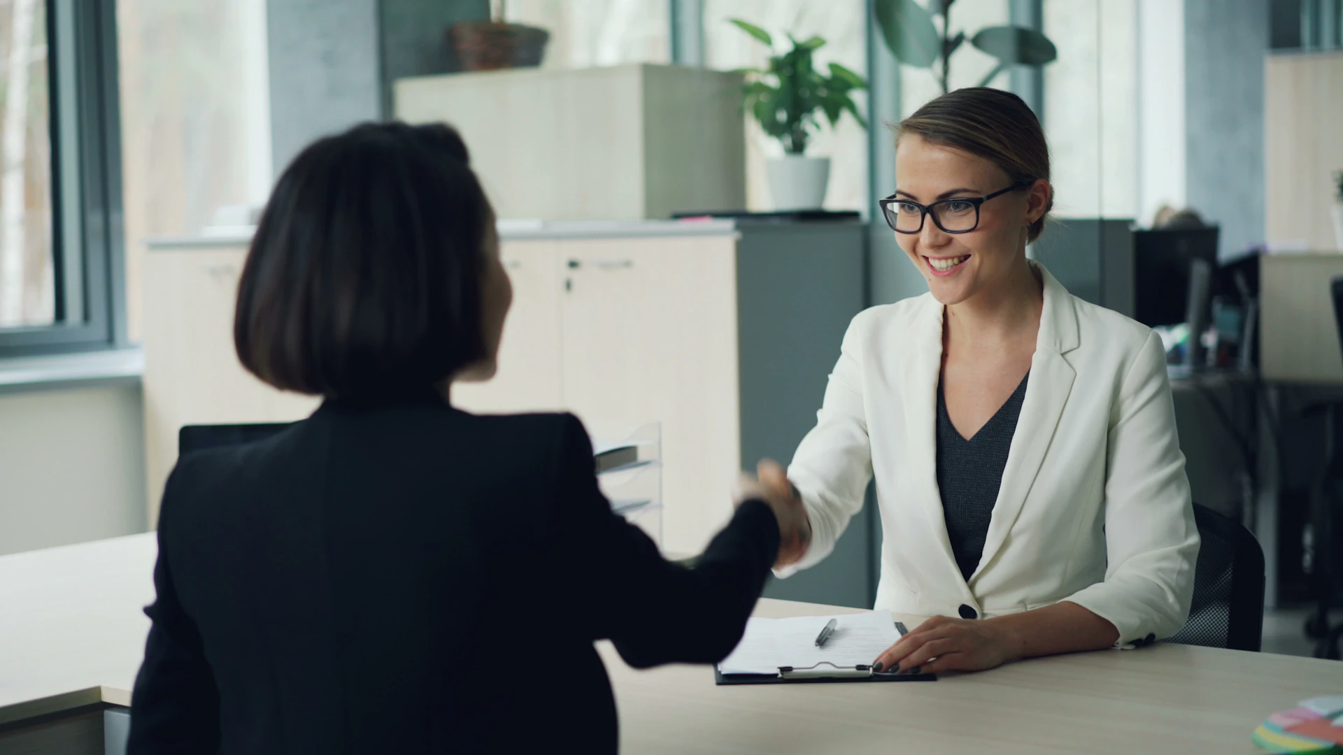 An HR interviewer shaking hands with a candidate