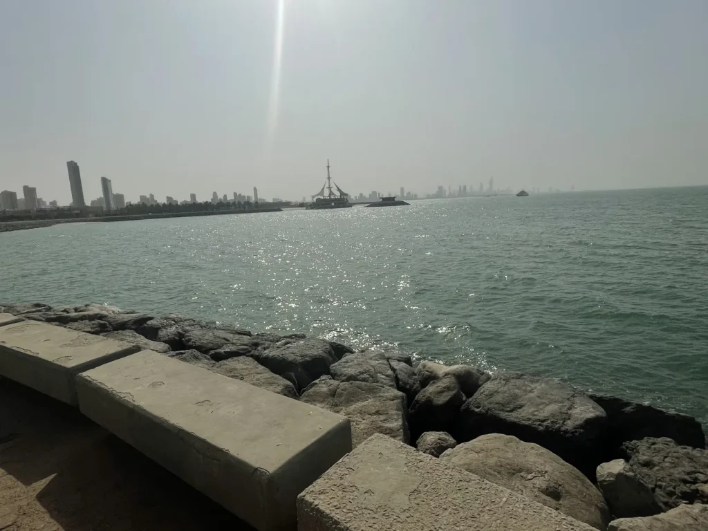 The Kuwait City skyline across the water from a seafront promenade