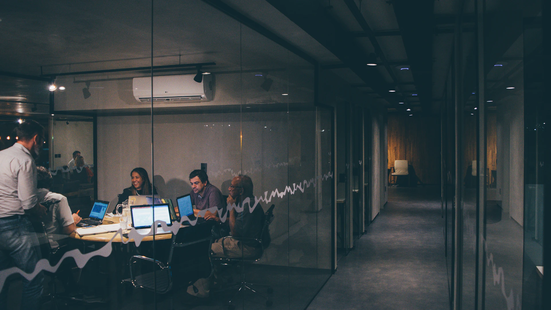A team working late behind a glass office wall