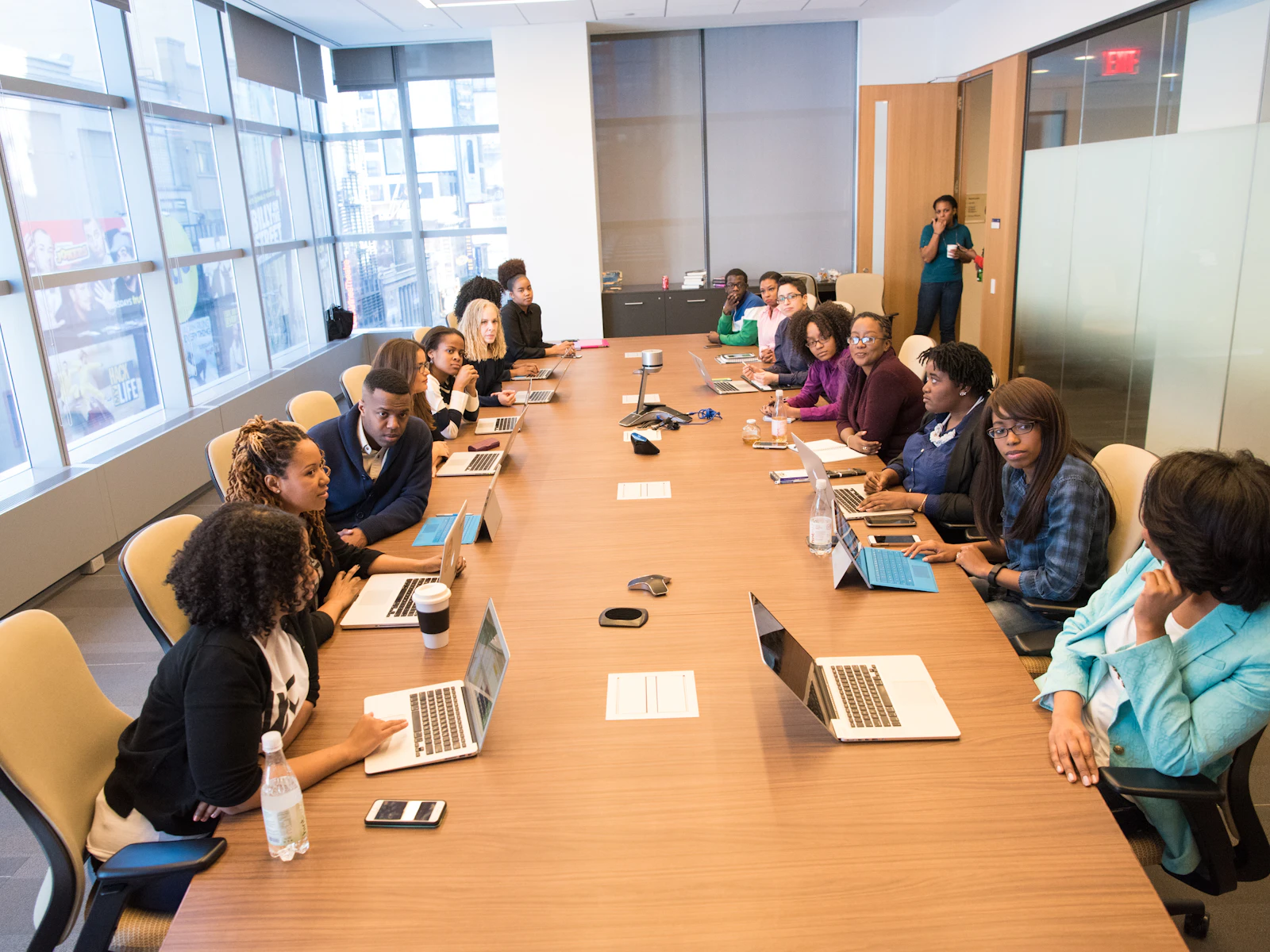 A large team working on laptops around a long table